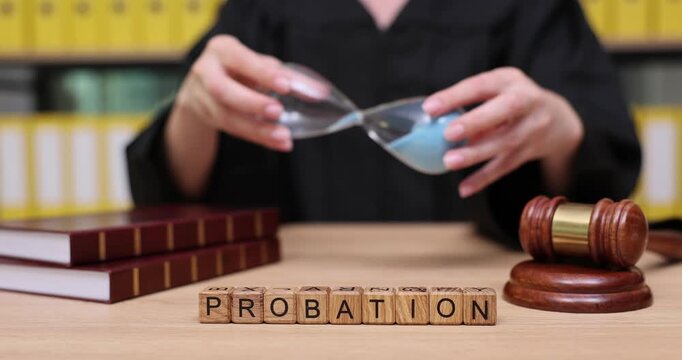 Handling time with care in a courtroom setting as sand flows through an hourglass during a probation discussion