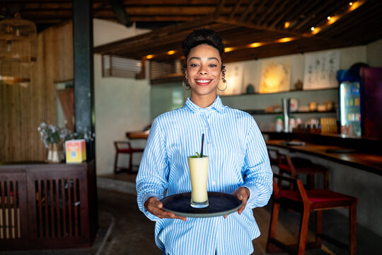 Smiling waitress at a cafe, showcasing friendly customer service, welcoming hospitality atmosphere
