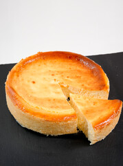 Baked cheesecake with a cut slice on board