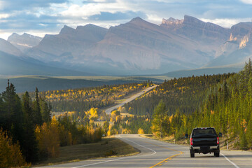 Truck driving on scenic autumn road in Alberta’s Rocky Mountains