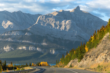 Autumn road to turquoise lake and mountains in Alberta, Canada