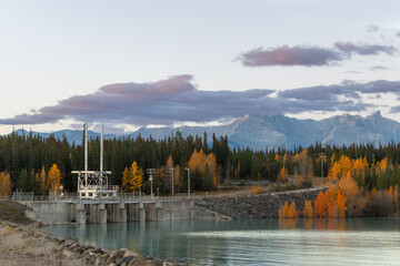 Hydroelectric dam with autumn forest and mountains in Alberta, Canada