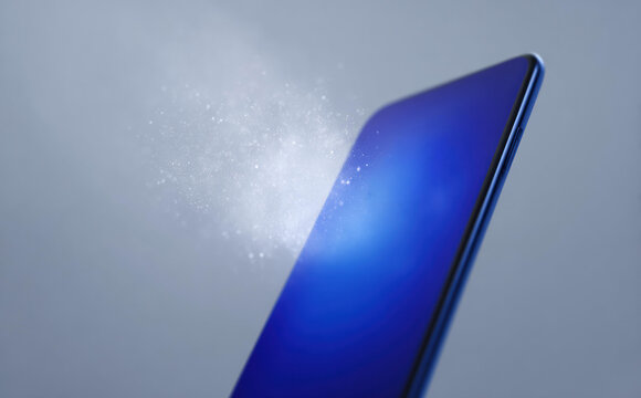 Modern blue smartphone screen receiving cleaning and disinfection from spray. concept of hygiene, protection, and care for mobile device against germs and bacteria