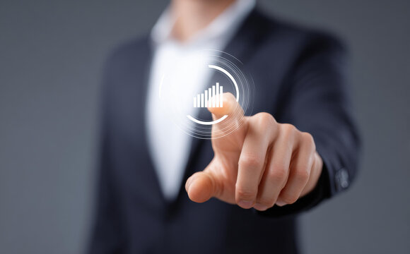 Focused businessman uses technology for business growth, touching digital interface with futuristic chart icon. Concept of data analysis and future strategy - Powered by Adobe