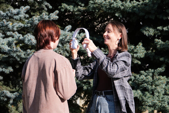 mother and daughter listening to music outdoors