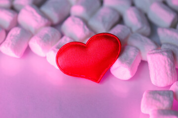 Obraz premium Red heart on a pink background with marshmallows. Romantic minimalist composition symbolizing love, tenderness, and sweetness. Perfect for Valentine’s Day, cards, or celebration design.