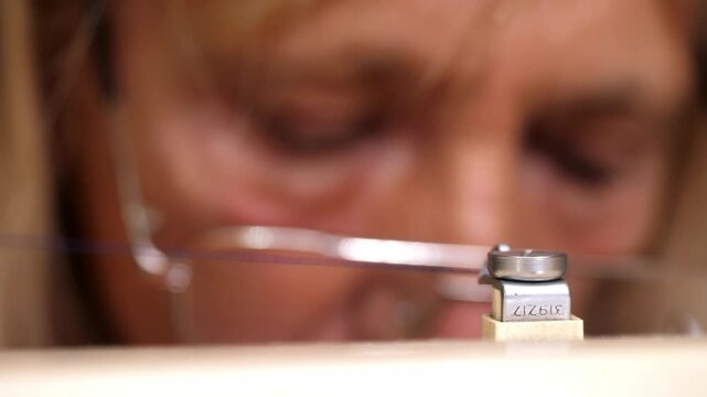Close-up of woman using electric sewing machine to fix bag