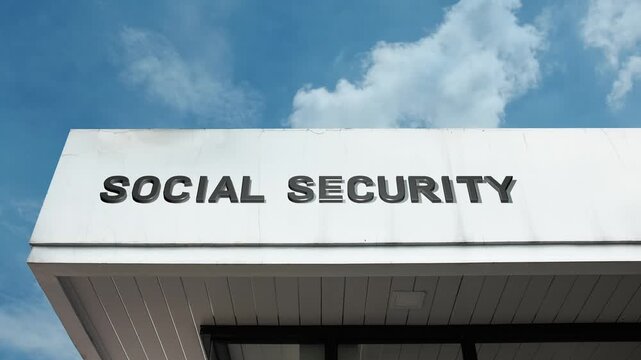 Social Security word sign displayed on a governmental or civic building under a clear blue sky, symbolizing public welfare, retirement, government aid, administration, and public services