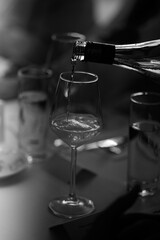 A waiter pours wine in a restaurant in the evening