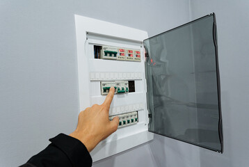 person switches off and on breaker, closeup shot showing finger toggling circuit breaker