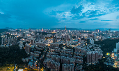 Obraz premium Panoramic view of the illuminated city skyline and sprawling urban landscape at night in Shenzhen, China.
