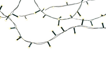 Warm white led holiday string lights, luminous bulbs, gentle bokeh, thin black wires, against a bright white seamless studio background with copy space, festive warmth concept