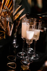 The waiter pours champagne into glasses before the celebration