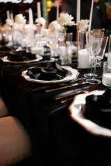 Luxurious setting of dark restaurant tables with candles and fresh flowers