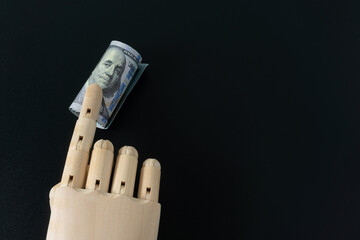 Wooden hand model and dollar banknote