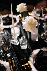 Luxurious setting of dark restaurant tables with candles and fresh flowers