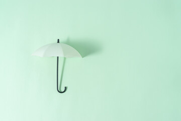 Umbrella toy on light green background with a copy space