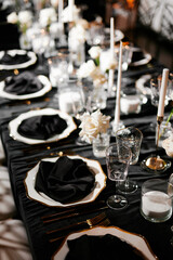 Luxurious setting of dark restaurant tables with candles and fresh flowers