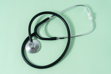 Stethoscope on light green background