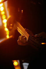 Close up look of a man playing the electric guitar during a concert, no faces are shown, shallow depth of field