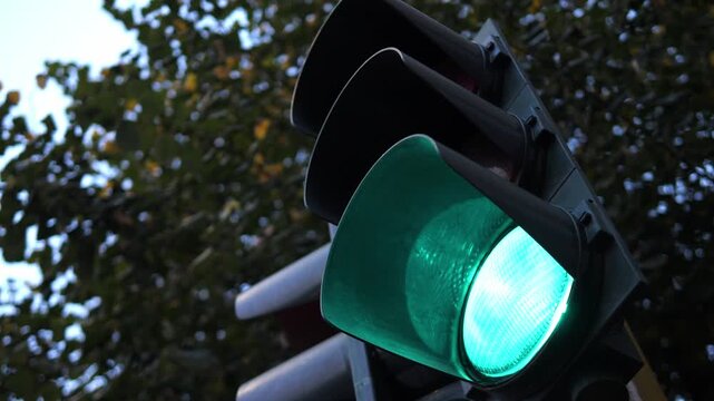 Low-angle view of changing traffic light from green to red in city street