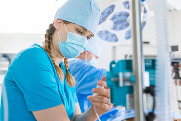 Surgical staff focused on a patient in the operating room during a medical procedure in a hospital.