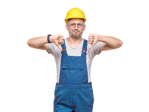 Displeased repairman showing thumbs down, isolated on white background. Dislike or negative concept. Craftsman against white wall