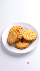 Butter cookies, arranged on a white plate against a blank backdrop