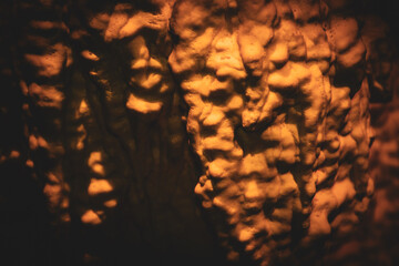 Detalles de una estalactita y sus detalles geol&oacute;gicos. Estalactita iluminada por un foco con tonos anaranjados.