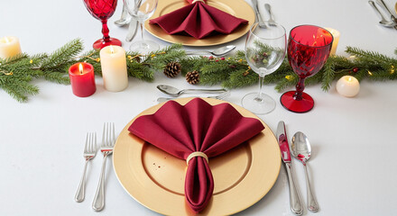 Elegant Christmas dinner table setting with red napkins and candles -  