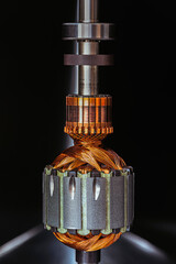 Electric motor rotor with metal structure and copper windings on dark background