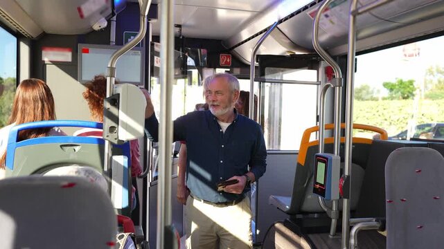 Diverse group of passengers getting on a city bus. An elderly man, a senior woman, and a young woman pay their fare using a validator