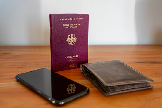 Neuer Deutscher Reisepass, Pass, Ausweis Deutschland - wichtiges Dokument f&uuml;r Urlaub und Einreise im Ausland - mit Geldbeutel und Handy