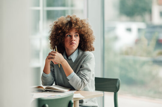 Fototapeta Woman thinking, looking away, pausing during study