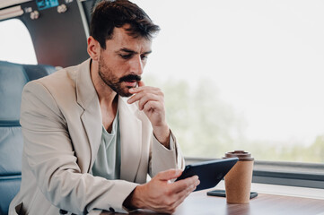 Man commuting to work, analyzing data on tablet