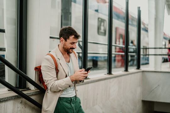 Man texting on smartphone at train station