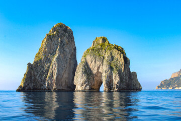Faraglioni Rock Arch Formations In Capri Italy With Big Blue Skies and Blue Water