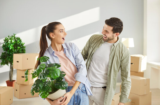 Happy couple with house plant, family celebrate relocation new modern apartment, husband, wife start living together, enjoy moving day to new flat starting cohabitation after marriage, eco green decor