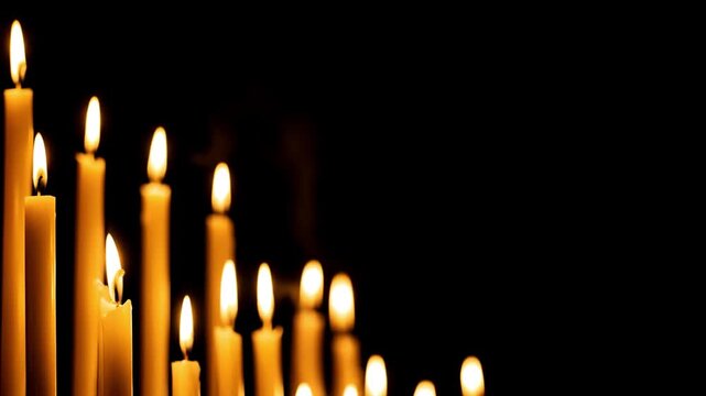 Candles burn brightly, their warm flames flickering in a sacred space. An inspiring, peaceful, and devotional atmosphere for themes of faith, hope, prayer, and memory. Black background