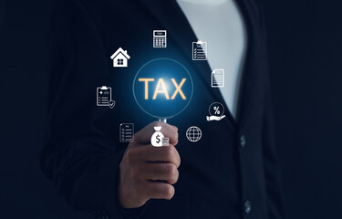 Businessman holding virtual TAX icon with financial and accounting symbols, representing digital tax management, financial planning, business consulting, and online finance technology.