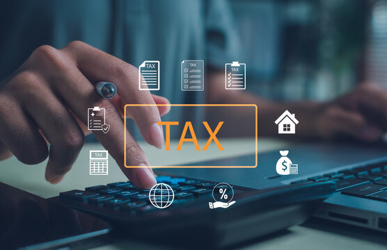 Businessman calculating tax using a calculator and laptop with digital icons, representing online taxation, financial planning, accounting, and business finance management concept. - Powered by Adobe