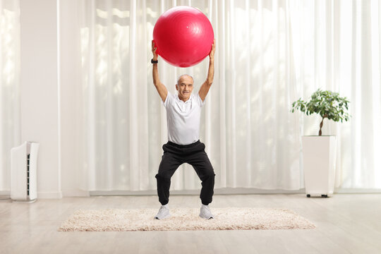 Elderly man exercising with a fitness ball