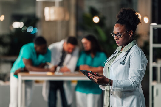 Doctor using digital tablet collaborating with medical team