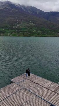 Couple on Dock Drone Flying Back Over Plav Lake