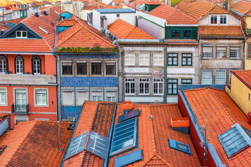 Colorful facades and traditional red tiled rooftops of old buildings in Porto city, Portugal. Medieval houses in old town of Oporto. Travel and tourism in Europe. Portuguese architecture