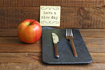 Apple and cutlery on wood