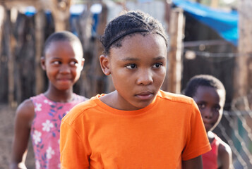 portrait african children in the village in the yard near the animal pen, sandy ground