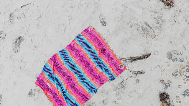 Aerial top down colorful Falsa blanket on beach summer day in southern San Diego California CA