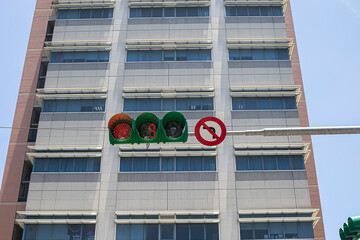 Traffic lights showing red signals with buildings in background.