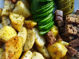 Freshly prepared roasted potatoes with vegetables and bread